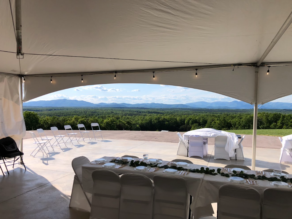 Reception table under tent framing Blue Ridge mountain views